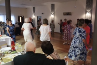 Seniorzy tańczą w sali